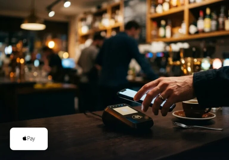 Paying with a phone at a contactless terminal in a bar.